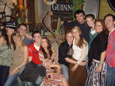 Un groupe de personnes entouré d'anciens équipements militaires sur le patio du pub